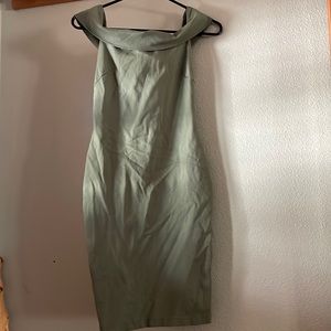 Green form fitting dress with off the shoulder sleeves.